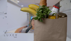 Staffer loading food pantry locker with grocery items for distribution