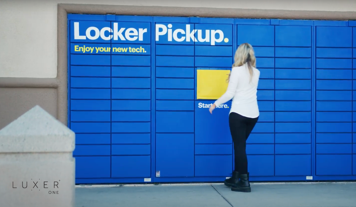 Woman approaching Luxer One BOPIS lockers at retail store to pickup order