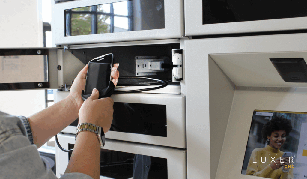Worker plugging in a handheld device to store in the Luxer One smart device management lockers