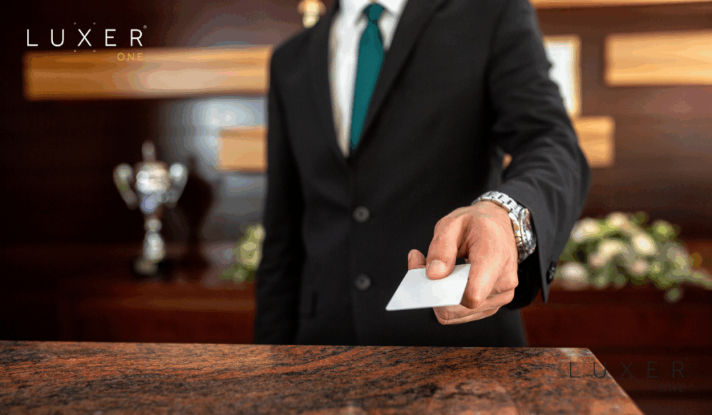Front desk staffer handing over access key card to guest at hotel