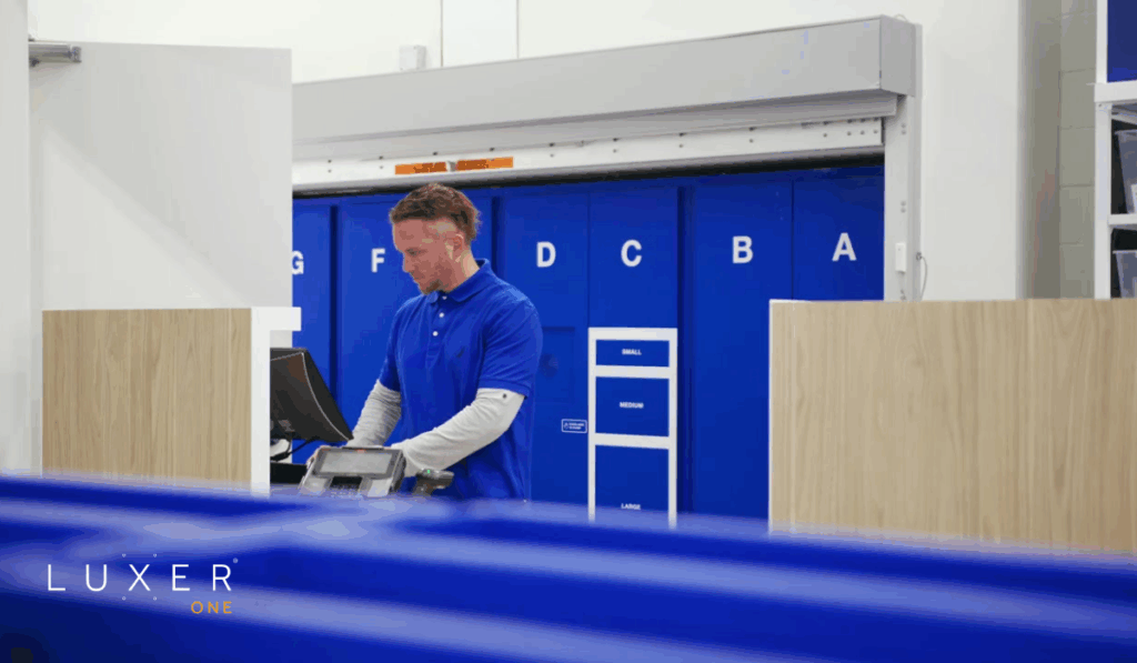 Fulfillment staff at retail store working on computer with rear loading BOPIS lockers in the background