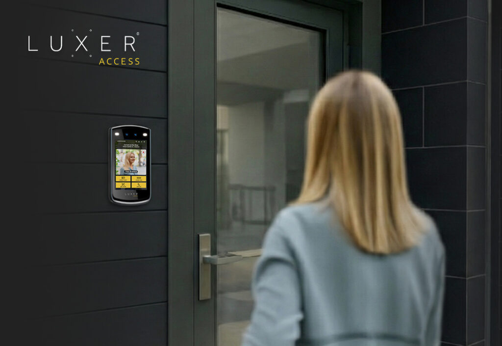 Resident approaching a multifamily building entrance equipped with a Luxer Access video intercom.