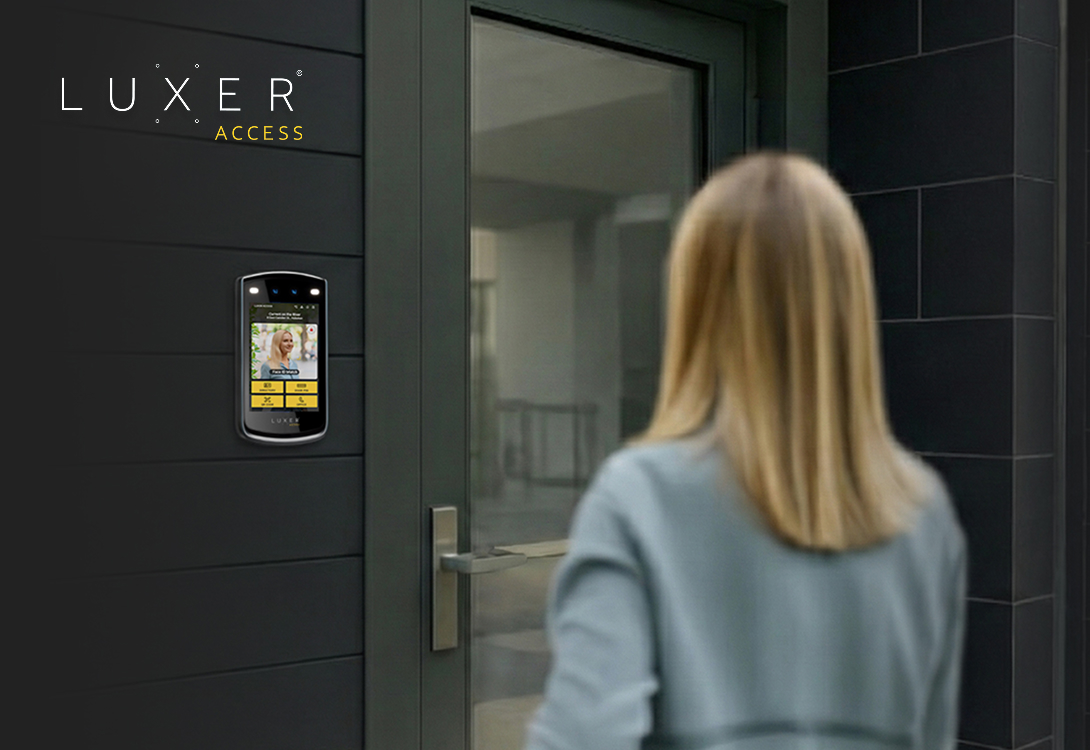 Resident approaching a multifamily building entrance equipped with a Luxer Access video intercom.