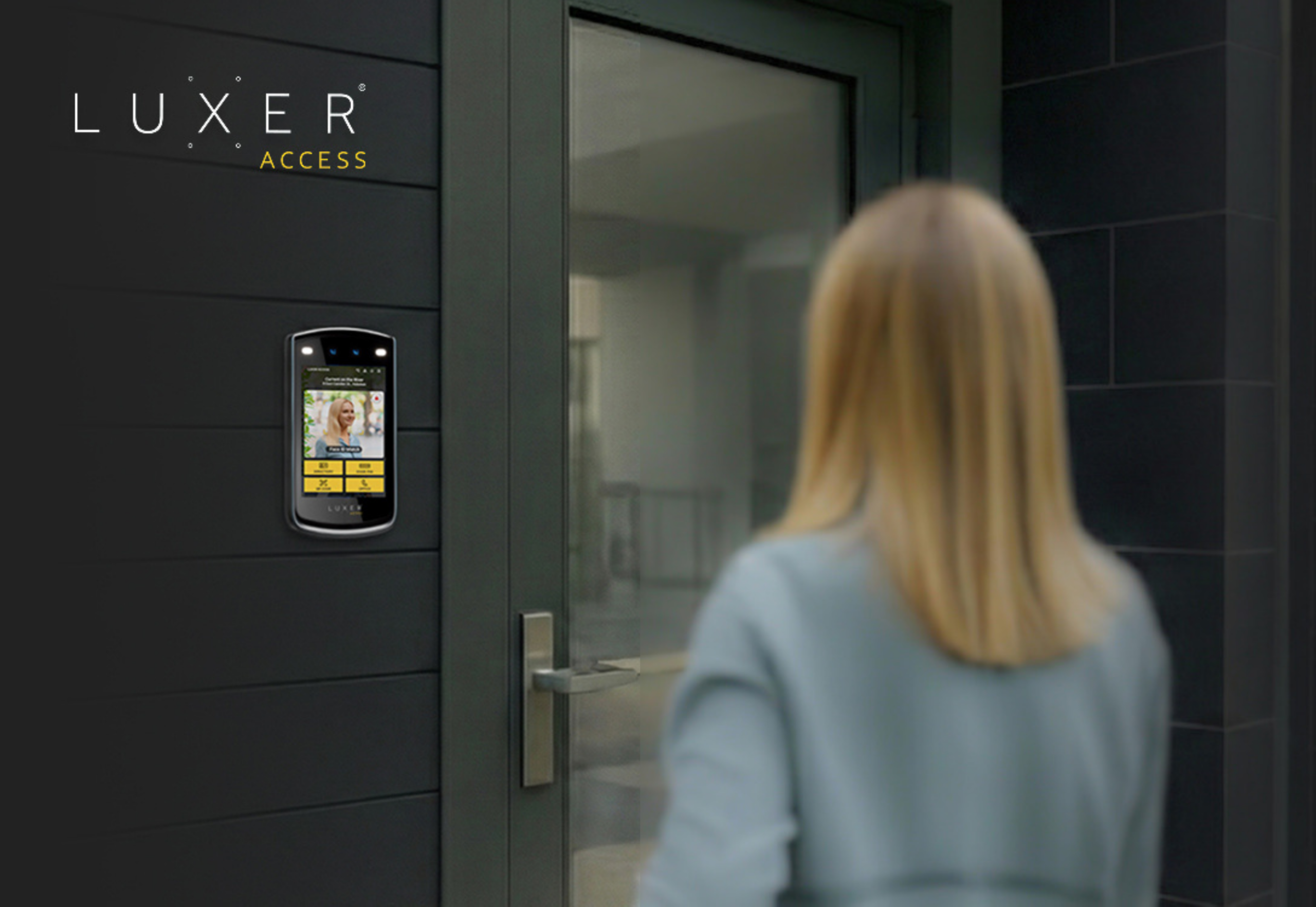 Resident approaching a multifamily building entrance equipped with a Luxer Access video intercom.